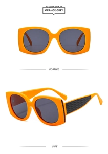 Detail of square orange sunglasses with smoke grey lenses and black lattice temples
