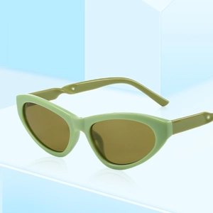 Fashionable Y2K cat-eye sunglasses with green frame and tinted lenses on minimalist stand