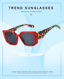 Detail view of red square sunglasses with camo print arms and UV400 protection lens