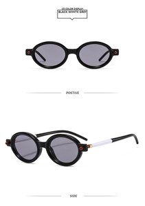 Détail de lunettes de soleil ovales rétro avec monture noire et branches bicolores noir-blanc