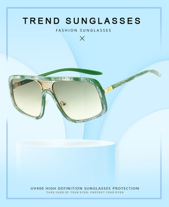 Detail einer grünen marmorierten Oversize-Sonnenbrille mit Goldsteg und UV400-Gläsern