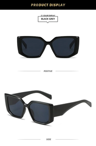 Detail view of bold square sunglasses with black glossy frames and dark grey lenses