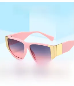 Close-up of pink square sunglasses with gradient lenses and gold hinge accents