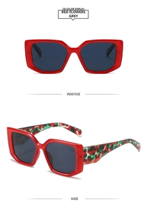 Macro detail of oversized square red sunglasses with floral textured wide temples
