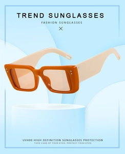 Detail of square sunglasses with orange frame, white temples and UV400 lenses
