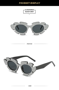 Detailansicht der floralen Glitzer-Sonnenbrille mit schwarzen ovalen Gläsern