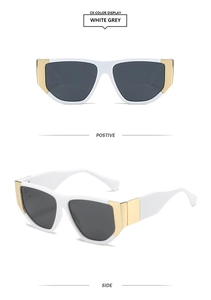 Detail of square white frames with dark grey lenses and gold metal corner accents