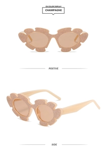 Detailansicht der champagnerfarbenen Blumen-Sonnenbrille mit glitzerndem Finish und Design