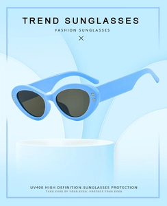Detail of blue cat-eye sunglasses with gold star accents and UV400 grey lenses