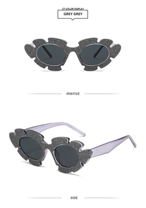 Detail einer floralen Glitzer-Sonnenbrille mit grauen Gläsern und fliederfarbenen Bügeln