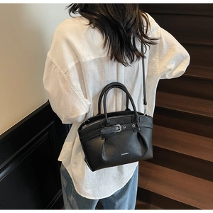 Detail of black lychee grain leather handbag with silver buckles and ZHCNMA logo
