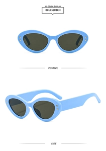 Detail of oval cat-eye sunglasses in blue-green with gold star accents on the frame