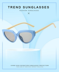 Detail of light blue cat-eye sunglasses with UV400 lenses on a blue minimalist pedestal