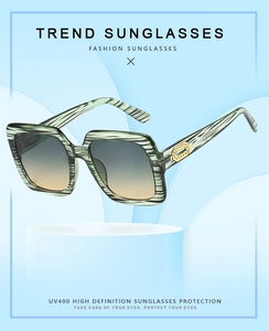 Detail of square oversized striped sunglasses with gradient lenses and gold accents