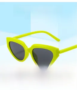 Detail of neon yellow cat eye sunglasses with dark lenses on blue geometric stands