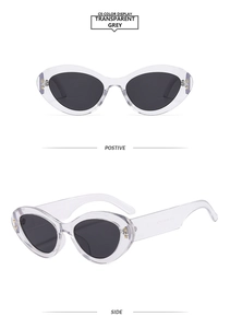 Detail view of transparent grey cat eye sunglasses with golden star-shaped rivets
