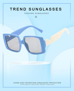 Detail of square sunglasses with blue frame and zigzag cream temples on a pedestal