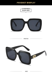 Detail view of black square sunglasses with grey lenses and gold hollow temple accents