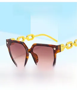 Détail de lunettes de soleil carrées en écaille avec branches en chaîne dorée