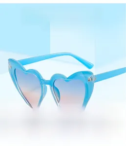 Vue détaillée de lunettes de soleil en forme de cœur avec verres dégradés sur fond bleu