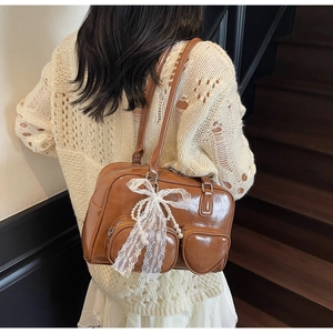 Close-up of retro brown bowling bag with heart pockets and pearl bow charms