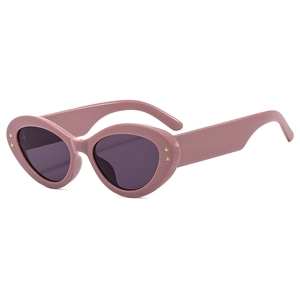 Pink cat-eye sunglasses with gold star accents and dark lenses on white background