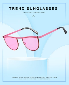 Detailed view of pink geometric sunglasses with UV400 protection on a display stand