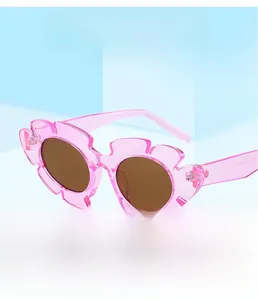 Dettaglio di occhiali da sole a forma di fiore rosa con montura in resina e cerniera