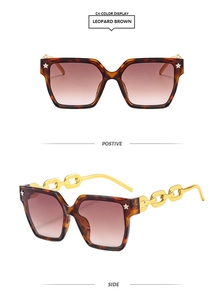 Détail de lunettes de soleil carrées léopard avec branches en chaîne dorée et étoiles