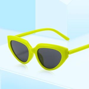 Neon yellow cat-eye sunglasses with dark lenses displayed on a light blue geometric stand