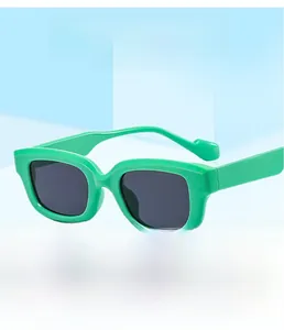 Détail de lunettes de soleil carrées vertes avec verres UV sur fond géométrique bleu