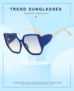 Detail of square geometric sunglasses with blue gradient lenses and gold metal temples