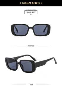 Detail view of stylish thick-framed rectangular sunglasses with dark grey lenses