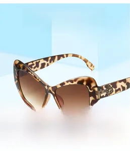 Detail of leopard print cat eye sunglasses with golden floral metal temple ornaments