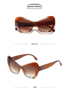 Detail view of cat eye sunglasses with brown gradient lenses and gold flower ornament