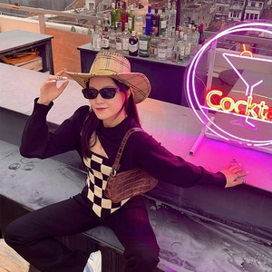 Lunettes de soleil carrées modernes et tricot chic dans un bar sur le toit à la mode