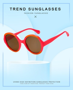 Détail de lunettes de soleil rondes avec monture orange contrastée et protection UV400