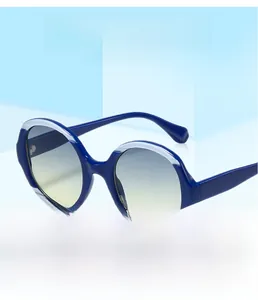 Détail de lunettes de soleil rondes avec contraste bleu marine et verres dégradés bleus
