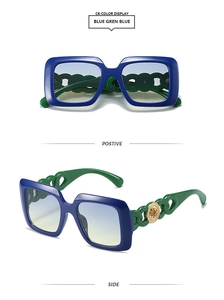 Détail de lunettes de soleil carrées avec branches à chaîne verte et emblèmes dorés