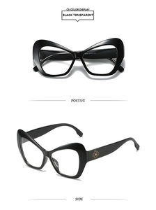 Detail of cat-eye frames featuring a gold swirl logo and polished black finish