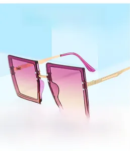 Detail of square oversized sunglasses with pink-yellow gradient lenses and gold rivets