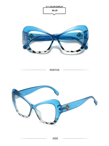 Detail of blue cat-eye glasses with marble pattern and gold flower decorative accents