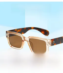 Detail of square vintage sunglasses featuring champagne frames and leopard print temples
