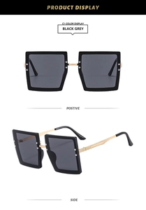 Detail view of square black sunglasses with gold metal temples and rivet accents