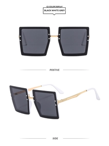 Detail view of square oversized sunglasses with black frames and gold metal temples