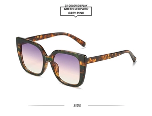 Detail view of cat eye sunglasses in green leopard frame with grey pink gradient lenses