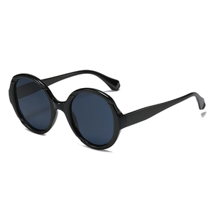 Lunettes de soleil rondes noires à la mode avec verres foncés en vue latérale à 45 degrés