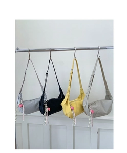 Detail of four colorful nylon dumpling bags with heart charms and adjustable wide straps