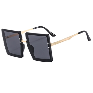 Fashionable oversized square sunglasses with black frame and gold metal textured temples
