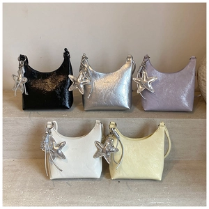 Détail de sacs à bandoulière en cinq couleurs avec des breloques en forme d'étoile